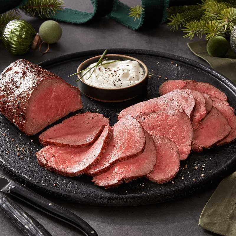 Two medium rare USDA Prime Beef Tenderloin sliced on a serving plate.