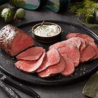 Two medium rare USDA Prime Beef Tenderloin sliced on a serving plate.